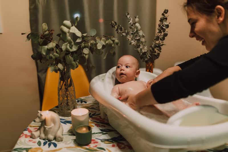Có người đến nhà chỉ mẹ tắm bé